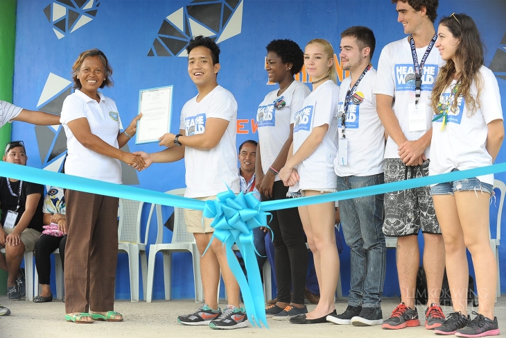 The student ambassadors of Limkokwing University accepting a certificate of appreciation from the Principal of Libaong National High School, Nilda P. Maglasang